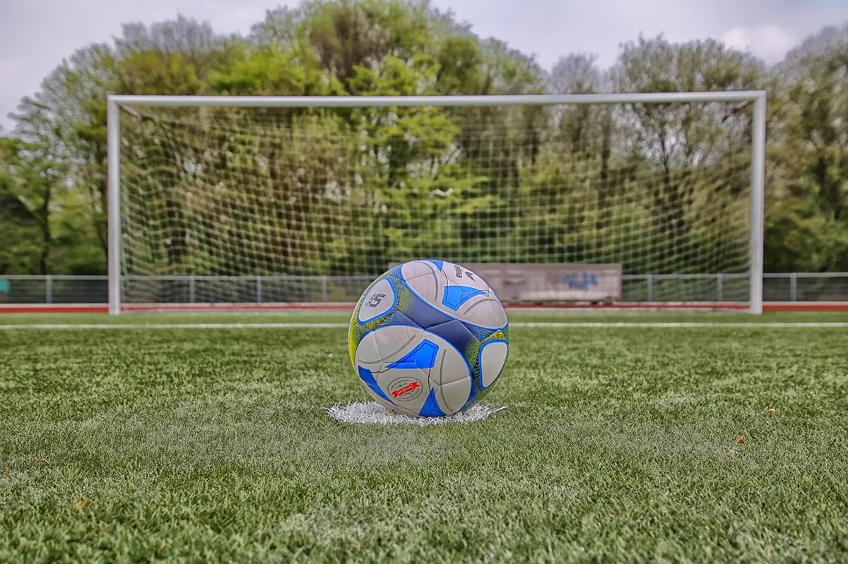 Footballeur avec ballon en match, tribunes pleines